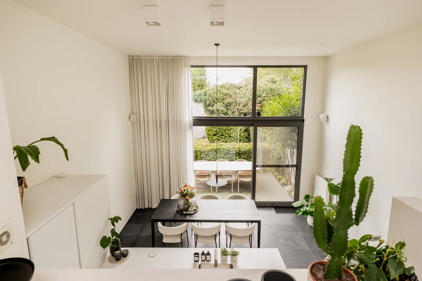 Zicht vanaf de mezzanine over de eetplaats naar de tuin